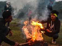 Men warm themselves by a fire on a cold winter morning in Kolkata, India, on December 8, 2024. (