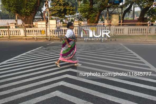 An old woman wears a saree and runs on the street on a winter morning in Kolkata, India, on December 8, 2024. 