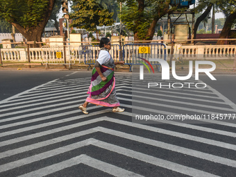 An old woman wears a saree and runs on the street on a winter morning in Kolkata, India, on December 8, 2024. (