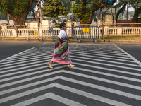 An old woman wears a saree and runs on the street on a winter morning in Kolkata, India, on December 8, 2024. (