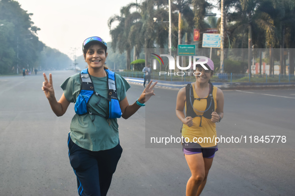 Women run on the street on a winter morning in Kolkata, India, on December 8, 2024. 