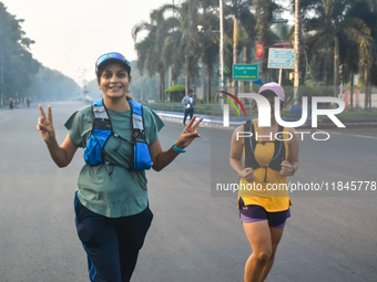 Women run on the street on a winter morning in Kolkata, India, on December 8, 2024. (