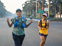 Women run on the street on a winter morning in Kolkata, India, on December 8, 2024. (