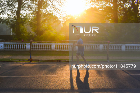 A person runs on the street on an early winter morning in Kolkata, India, on December 8, 2024. 