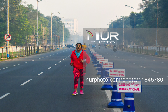 People run on the street on an early winter morning in Kolkata, India, on December 8, 2024. 