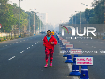 People run on the street on an early winter morning in Kolkata, India, on December 8, 2024. (