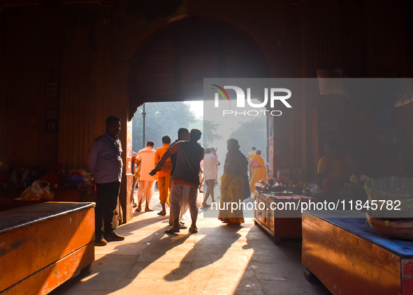 People stand in sunlight on an early winter morning in Kolkata, India, on December 8, 2024. 