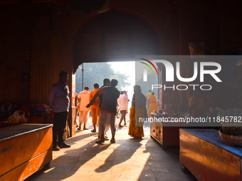 People stand in sunlight on an early winter morning in Kolkata, India, on December 8, 2024. (