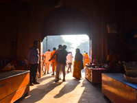 People stand in sunlight on an early winter morning in Kolkata, India, on December 8, 2024. (