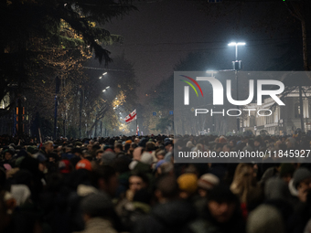 Anti-government protesters carry EU and Georgian flags as they rally for a tenth consecutive day of mass demonstrations against the governme...