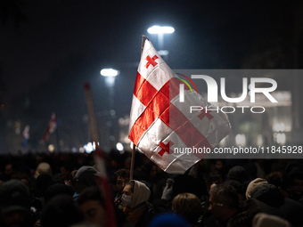 Anti-government protesters carry EU and Georgian flags as they rally for a tenth consecutive day of mass demonstrations against the governme...