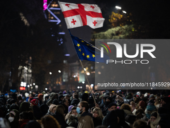 Anti-government protesters carry EU and Georgian flags as they rally for a tenth consecutive day of mass demonstrations against the governme...