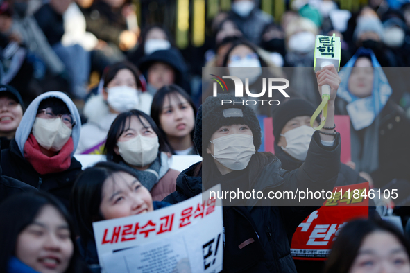 Tens of thousands of citizens gather across from the National Assembly in Yeouido, Seoul, South Korea, on December 8, 2024, holding signs th...