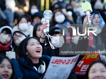 Tens of thousands of citizens gather across from the National Assembly in Yeouido, Seoul, South Korea, on December 8, 2024, holding signs th...