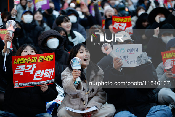 Tens of thousands of citizens gather across from the National Assembly in Yeouido, Seoul, South Korea, on December 8, 2024, holding signs th...