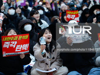 Tens of thousands of citizens gather across from the National Assembly in Yeouido, Seoul, South Korea, on December 8, 2024, holding signs th...