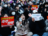 Tens of thousands of citizens gather across from the National Assembly in Yeouido, Seoul, South Korea, on December 8, 2024, holding signs th...