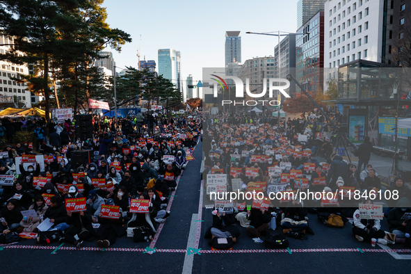 Tens of thousands of citizens gather across from the National Assembly in Yeouido, Seoul, South Korea, on December 8, 2024, holding signs th...