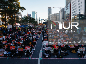 Tens of thousands of citizens gather across from the National Assembly in Yeouido, Seoul, South Korea, on December 8, 2024, holding signs th...