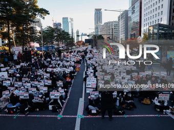 Tens of thousands of citizens gather across from the National Assembly in Yeouido, Seoul, South Korea, on December 8, 2024, holding signs th...