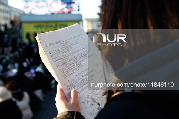 A student participates in a protest in Seoul, South Korea, on December 8, 2024, across from the National Assembly, studying for next week's...