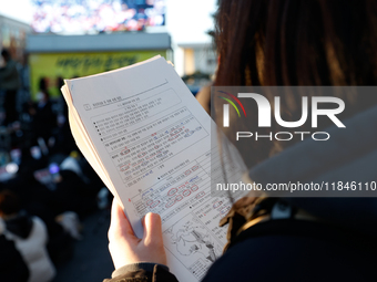 A student participates in a protest in Seoul, South Korea, on December 8, 2024, across from the National Assembly, studying for next week's...