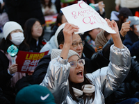 A student protests in Yeouido, Seoul, South Korea, on December 8, 2024, across from the National Assembly, holding a sign that reads, ''Pres...