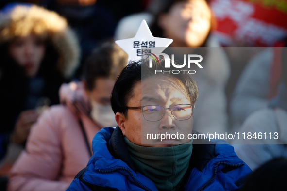 A man protests in Yeouido, Seoul, South Korea, on December 8, 2024, across from the National Assembly, holding a sign that reads, ''Impeach...