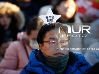 A man protests in Yeouido, Seoul, South Korea, on December 8, 2024, across from the National Assembly, holding a sign that reads, ''Impeach...