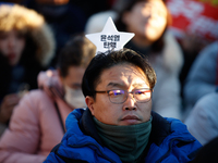 A man protests in Yeouido, Seoul, South Korea, on December 8, 2024, across from the National Assembly, holding a sign that reads, ''Impeach...