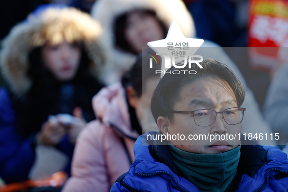 A man protests in Yeouido, Seoul, South Korea, on December 8, 2024, across from the National Assembly, holding a sign that reads, ''Impeach...