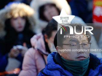 A man protests in Yeouido, Seoul, South Korea, on December 8, 2024, across from the National Assembly, holding a sign that reads, ''Impeach...