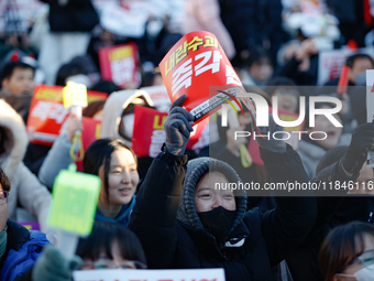 Thousands of citizens gather across from the National Assembly in Yeouido, in Seoul, South Korea, on December 8, 2024, holding signs that re...