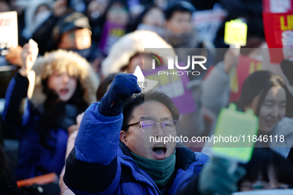 A man protests in Yeouido, Seoul, South Korea, on December 8, 2024, across from the National Assembly, holding a sign that reads, ''Impeach...