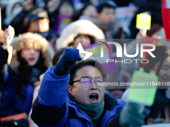 A man protests in Yeouido, Seoul, South Korea, on December 8, 2024, across from the National Assembly, holding a sign that reads, ''Impeach...