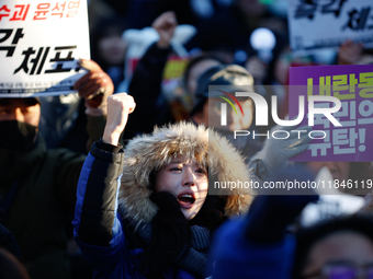 Thousands of citizens gather across from the National Assembly in Yeouido, in Seoul, South Korea, on December 8, 2024, holding signs that re...