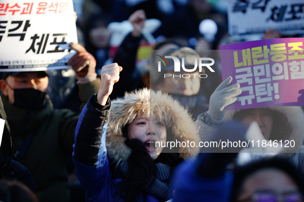 Thousands of citizens gather across from the National Assembly in Yeouido, in Seoul, South Korea, on December 8, 2024, holding signs that re...