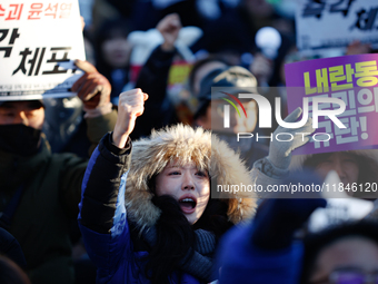 Thousands of citizens gather across from the National Assembly in Yeouido, in Seoul, South Korea, on December 8, 2024, holding signs that re...