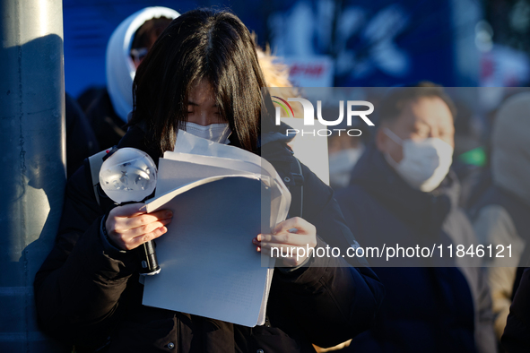 A student participates in a protest in Seoul, South Korea, on December 8, 2024, across from the National Assembly, studying for next week's...