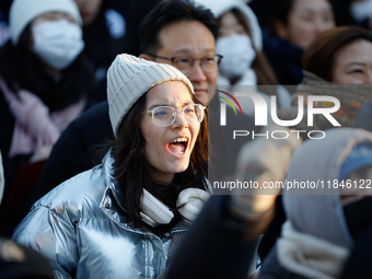 A student protests in Yeouido, Seoul, South Korea, on December 8, 2024, across from the National Assembly, holding a sign that reads, ''Pres...