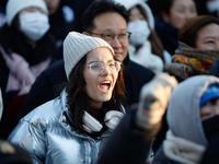 A student protests in Yeouido, Seoul, South Korea, on December 8, 2024, across from the National Assembly, holding a sign that reads, ''Pres...