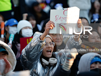 A student protests in Yeouido, Seoul, South Korea, on December 8, 2024, across from the National Assembly, holding a sign that reads, ''Pres...