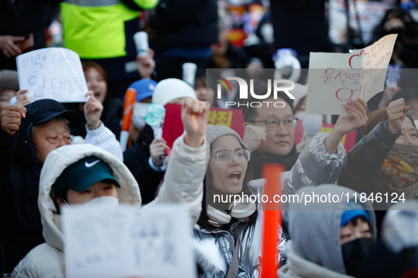 A student protests in Yeouido, Seoul, South Korea, on December 8, 2024, across from the National Assembly, holding a sign that reads, ''Pres...