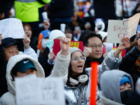 A student protests in Yeouido, Seoul, South Korea, on December 8, 2024, across from the National Assembly, holding a sign that reads, ''Pres...