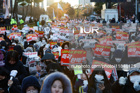 Tens of thousands of citizens gather across from the National Assembly in Yeouido, Seoul, South Korea, on December 8, 2024, holding signs th...