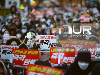 Tens of thousands of citizens gather across from the National Assembly in Yeouido, Seoul, South Korea, on December 8, 2024, holding signs th...