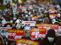 Tens of thousands of citizens gather across from the National Assembly in Yeouido, Seoul, South Korea, on December 8, 2024, holding signs th...