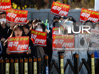 Tens of thousands of citizens gather across from the National Assembly in Yeouido, Seoul, South Korea, on December 8, 2024, holding signs th...