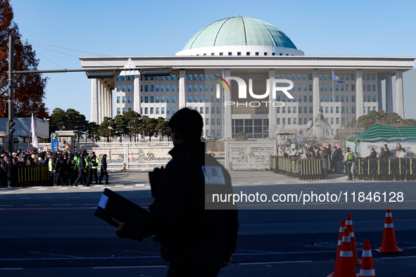 Tens of thousands of citizens gather across from the National Assembly in Yeouido, Seoul, South Korea, on December 8, 2024, holding signs th...