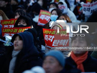 Thousands of citizens gather across from the National Assembly in Yeouido, in Seoul, South Korea, on December 8, 2024, holding signs that re...